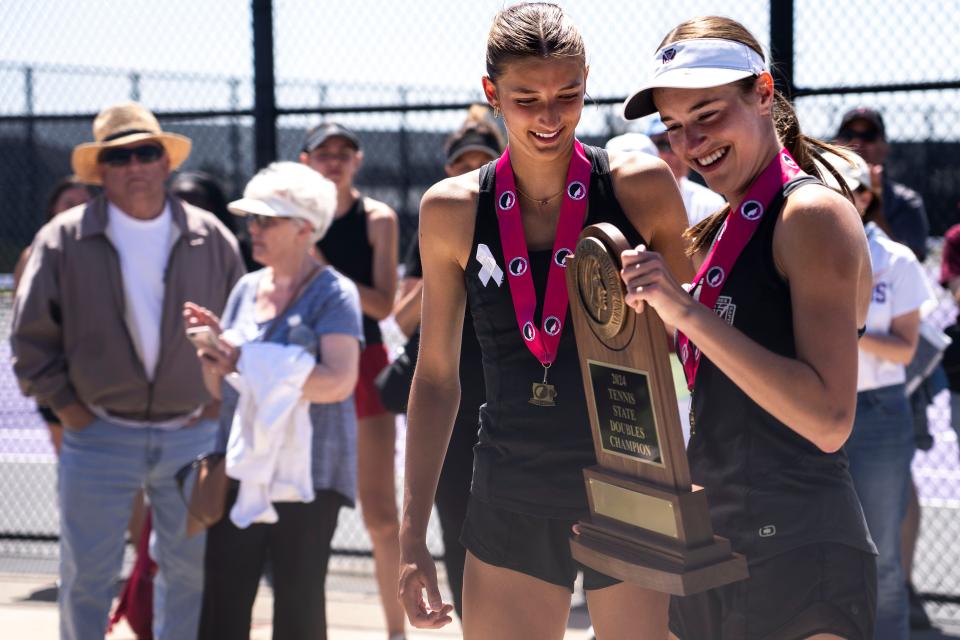 Juju Mauro y Grace Frye de Dowling sonríen mientras sostienen su trofeo de campeonato durante el campeonato estatal de tenis femenino de secundaria de Iowa en Johnston High School el sábado 25 de mayo de 2024 en Johnston.