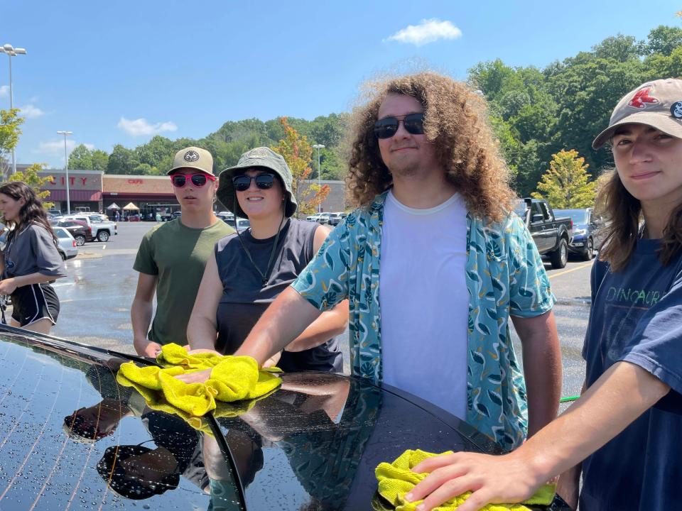 Isaac Parnell, 16, Cadence Hayes, 17, Patrick Howard, 17, and Ethan Hayes, 15, wash a car with gusto trying to get through as many as possible as quickly as possible at the Hardin Valley Academy Band car wash at Food City on Middlebrook Pike Saturday, July 23, 2022.