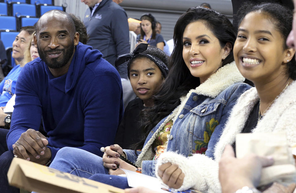 FILE - In this Nov. 21, 2017, file photo, from left, Los Angeles Lakers legend Kobe Bryant, his daughter Gianna Maria-Onore Bryant, wife Vanessa and daughter Natalia Diamante Bryant are seen before an NCAA college women's basketball game between Connecticut and UCLA, in Los Angeles. Vanessa Bryant says she is focused on “finding the light in darkness” in an emotional story in People magazine. She details how she attempts to push forward after her husband, Kobe Bryant, and daughter Gigi died in a helicopter crash in early 2020. (AP Photo/Reed Saxon, File)