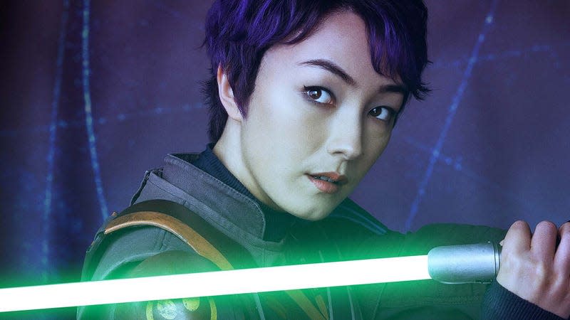 An image shows Sabine Wren with short hair and holding a green lightsaber. 