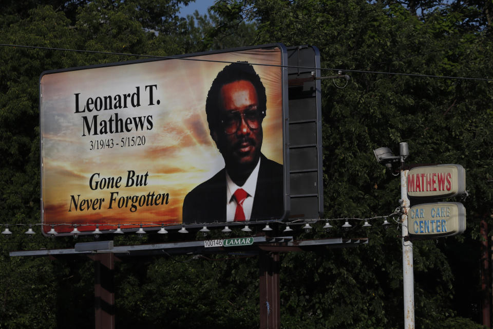 A billboard remembering Leonard T. Mathews, who people say was a pillar of the community in the impoverished east side of Saginaw, Mich., stands next to the business sign of his former car care service on Monday, June 29, 2020. (AP Photo/Charles Rex Arbogast)