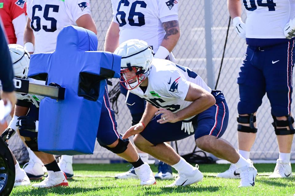 Patriots tight end Hunter Henry focuses on a tackle sled during training camp this week.