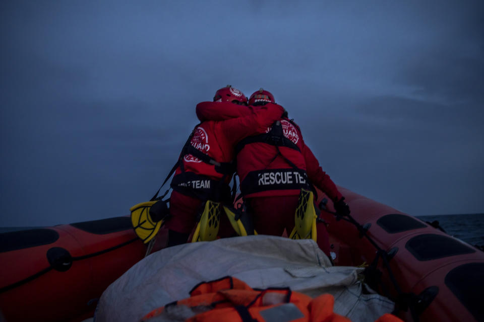 Rescuers of the Spanish NGO Open Arms, Alberto Agrelo and Alejandro Samper embrace in a gesture of encouragement as they prepare for a possible rescue pn a dingy in the Mediterranean Sea, Saturday, Feb.6, 2021. Various African migrants drifting in the Mediterranean Sea after fleeing Libya on unseaworthy boats have been rescued. In recent days, the Libyans had already thwarted eight rescue attempts by the Open Arms, a Spanish NGO vessel, harassing and threatening its crew in international waters. (AP Photo/Bruno Thevenin)