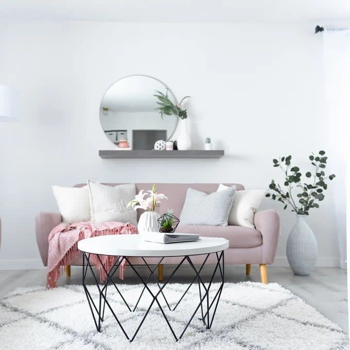 Reviewer's photo of the rug in the color White styled with a pink couch and a geometric coffee table