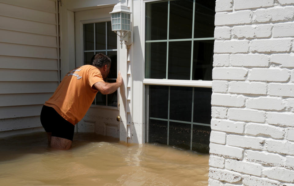 Patrice Laporte looks to see how much water is in his house on Sept. 1.