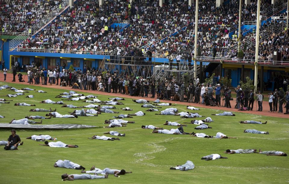 Performers re-enact the events at a public ceremony to mark the 20th anniversary of the Rwandan genocide, at Amahoro stadium in Kigali, Rwanda Monday, April 7, 2014. Sorrowful wails and uncontrollable sobs resounded Monday as thousands of Rwandans packed the country's main sports stadium to mark the 20th anniversary of the beginning of a devastating 100-day genocide. (AP Photo/Ben Curtis)