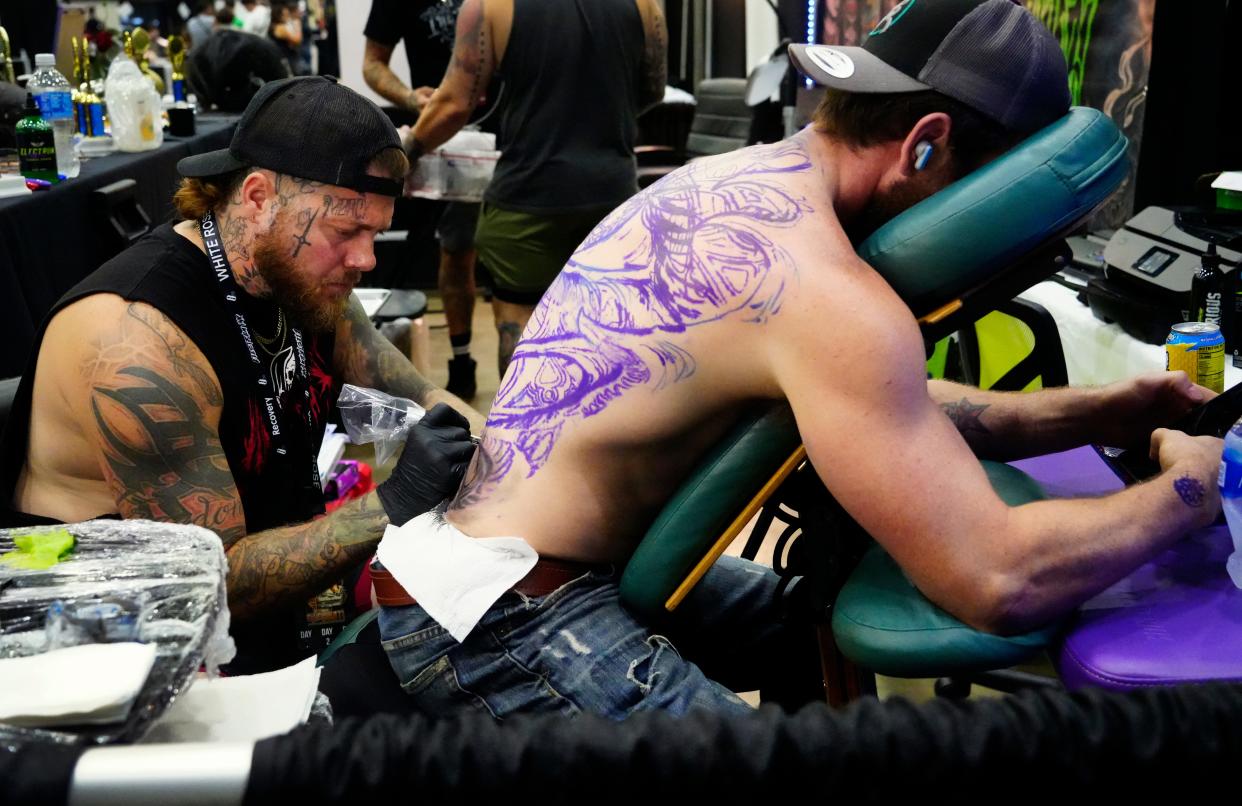 Cody Montgomery, Iron Pen Tattoo Collection in Chillicothe, works on a full back tattoo for Justin Stewart at the Cincinnati Tattoo Arts Festival in 2023. This year's festival runs May 10-12 at the Duke Energy Convention Center.