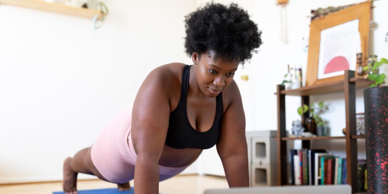 woman exercising at home following a fitness video online