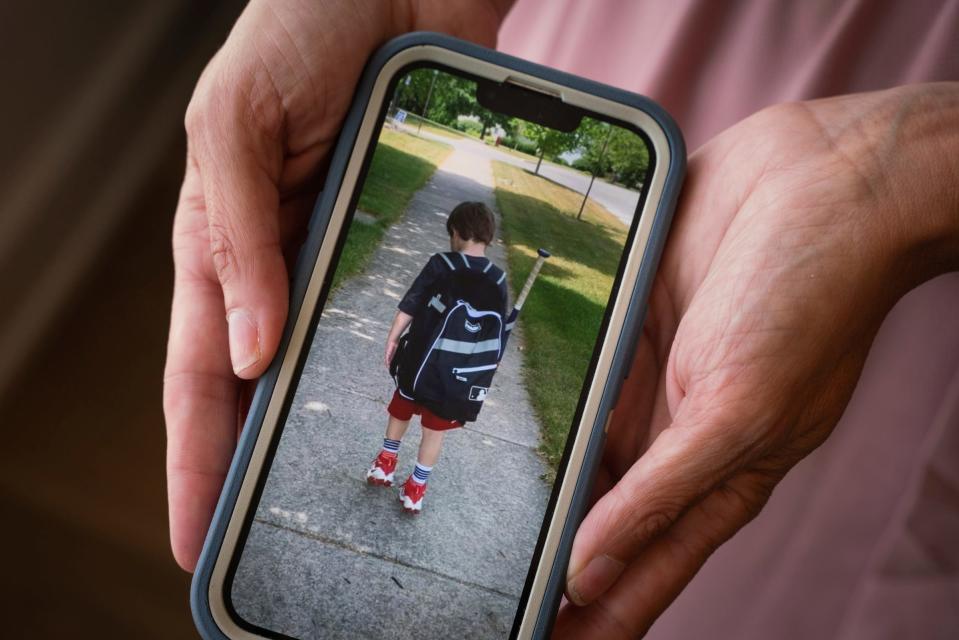 Jaime Nelson-Molnar, 44, of Ann Arbor, shows an old photograph of her son who has autism, around the age he was when he was assaulted by a school bus aide. Nelson-Molnar is now suing the Ann Arbor Public Schools over the incident.