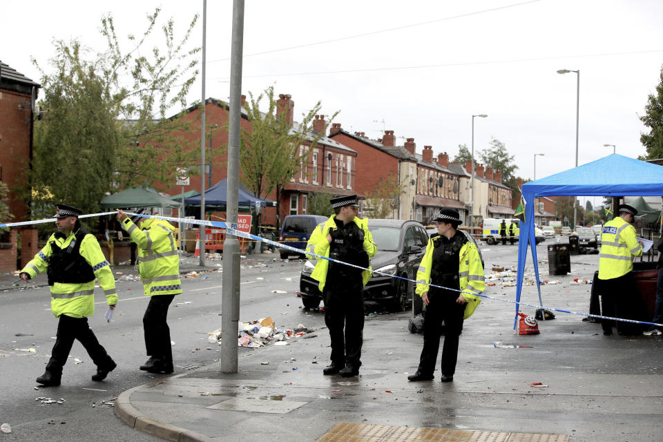 Police officers at the scene in Claremont Road in Manchester after a shooting Sunday, Aug. 12, 2018. Police in Manchester say some people have been hospitalized as the result of a shooting after a Caribbean carnival in the city. (Peter Byrne/PA via AP)