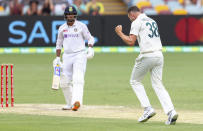 Australia's Josh Hazlewood, right, celebrates after dismissing India's Mayank Agarwal, left, during play on day three of the fourth cricket test between India and Australia at the Gabba, Brisbane, Australia, Sunday, Jan. 17, 2021. (AP Photo/Tertius Pickard)