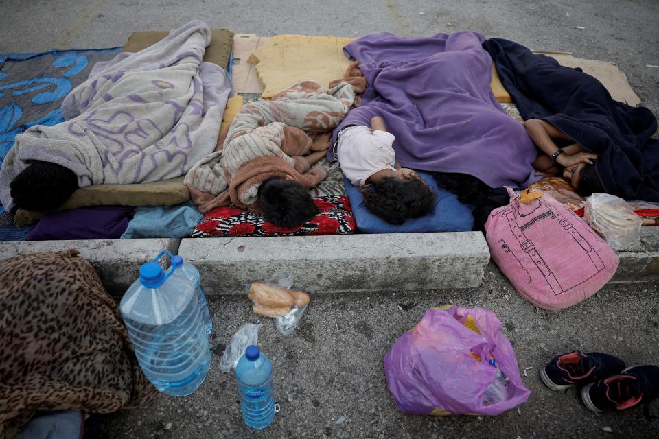 Five children sleep on the street next to bottles of water, carrier bags and bread amid fresh Israeli airstrikes on Beirut (REUTERS)