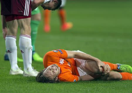 Daley Blind of the Netherlands lies injured after a challenge with Latvia's Eduards Viskanovs during their Euro 2016 Group A qualifying soccer match in Amsterdam November 16, 2014. REUTERS/Paul Vreeker/United Photos