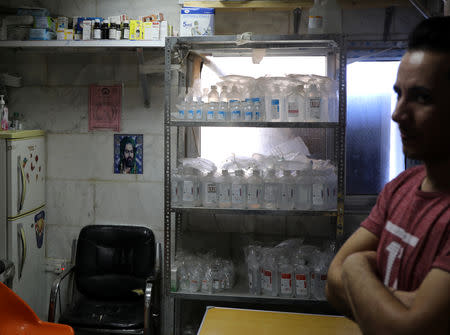 A hospital worker stands in a pharmacy run by the Hashid Shaabi Shia militia group in Hilla, Iraq, July 5, 2018. Picture taken July 5, 2018. REUTERS/Marius Bosch