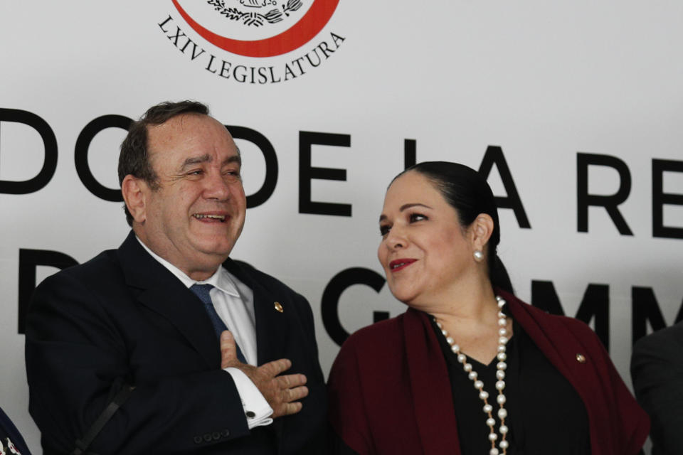 Guatemala's President Alejandro Giammattei, left, laughs as Mexican Senate President Monica Fernandez Balboa speaks to him between the playing of the two countries' national anthems, as he arrives to speak to the Mexican Senate in Mexico City, Thursday, Feb. 6, 2020. (AP Photo/Rebecca Blackwell)