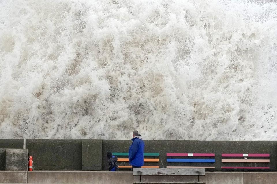 People look at the waves created by high winds and spring tides hitting the sea wall at New Brighton promenade in Liverpool (Getty)