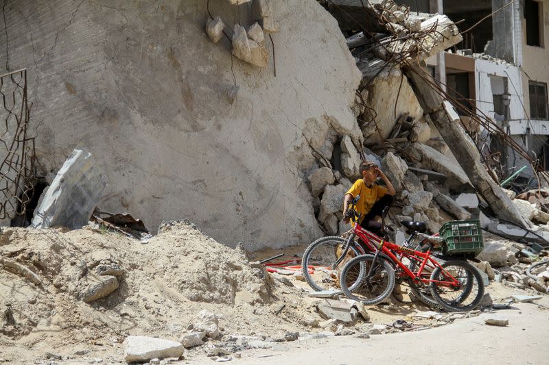 FILE PHOTO: A Palestinian boy sits at the rubble of a house destroyed by Israeli strikes, amid the ongoing conflict between Israel and Hamas, in the northern Gaza Strip