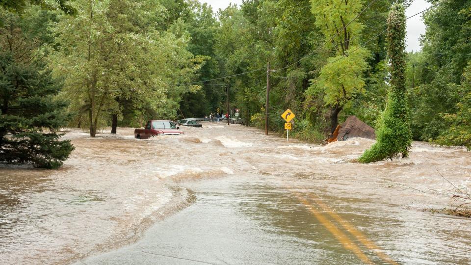 flooded road with cars trying to drive through