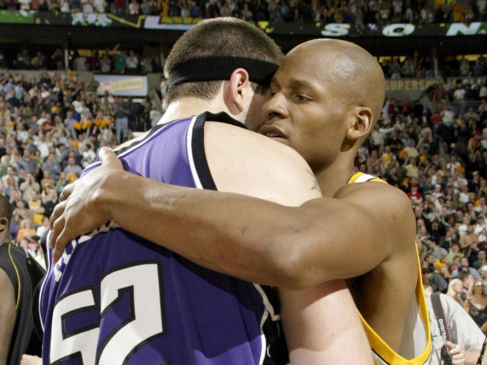 Two basketball players hug each other.