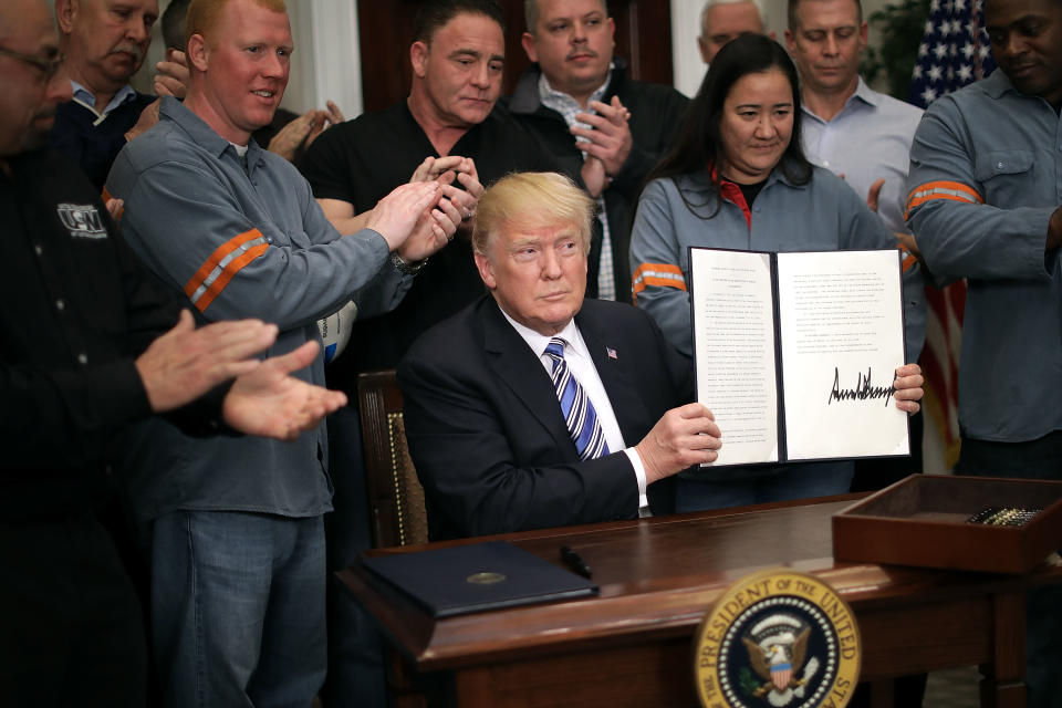 WASHINGTON, DC - MARCH 08:  Surrounded by applauding steel and aluminum workers, U.S. President Donald Trump holds up the 'Section 232 Proclamation' on steel imports that he signed in Roosevelt Room the the White House March 8, 2018 in Washington, DC. Trump announced last week that he will impose a 25-percent tarriff on imported steel and a 10-percent tarriff on imported alumninum.  (Photo by Chip Somodevilla/Getty Images)