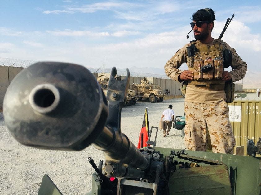 An Afghan soldier wearing a headset stands next to equipment at Bagram.