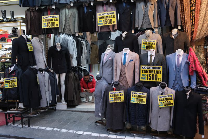 A shopkeeper uses his mobile phone as he waits for customers at a popular middle-class shopping district in Istanbul