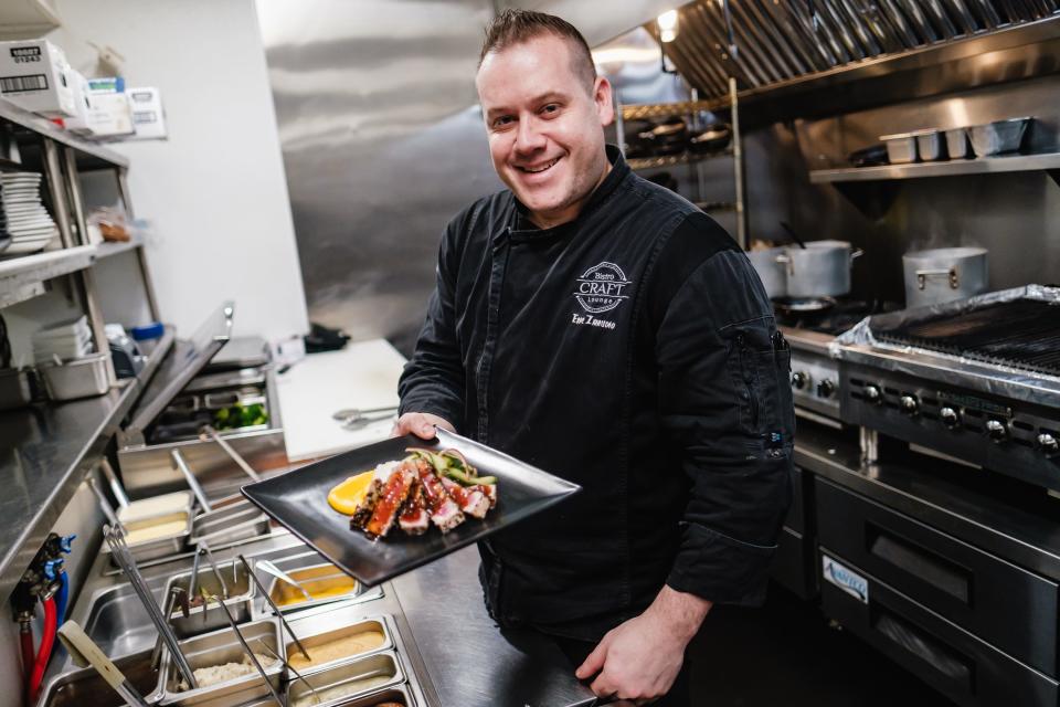 Eric Zamudio, executive chef at Craft Bistro & Lounge proudly shows the chef's special of grilled sesame crusted ahi tuna with sushi rice, cucumber salad, citrus pureed carrot and teriyaki, in New Philadelphia.