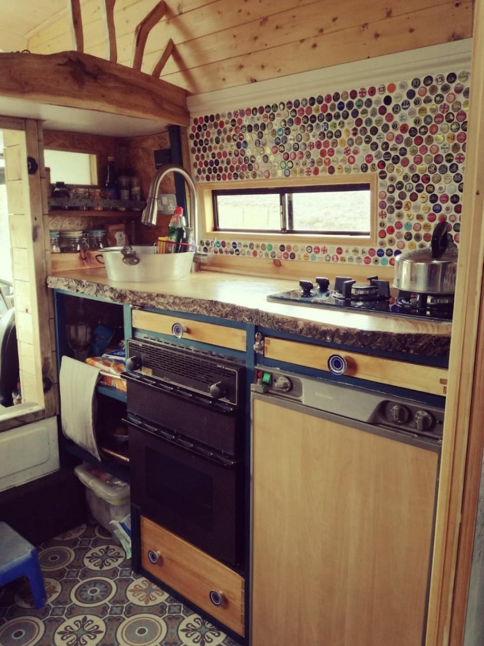 A tiled kitchen with a gas oven and stovetop in the Firetruck Family's van conversion.