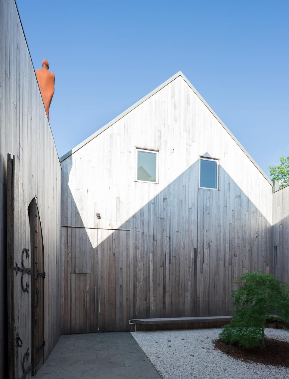 An Antony Gormley sculpture is installed on the roof above the cedar-walled courtyard.