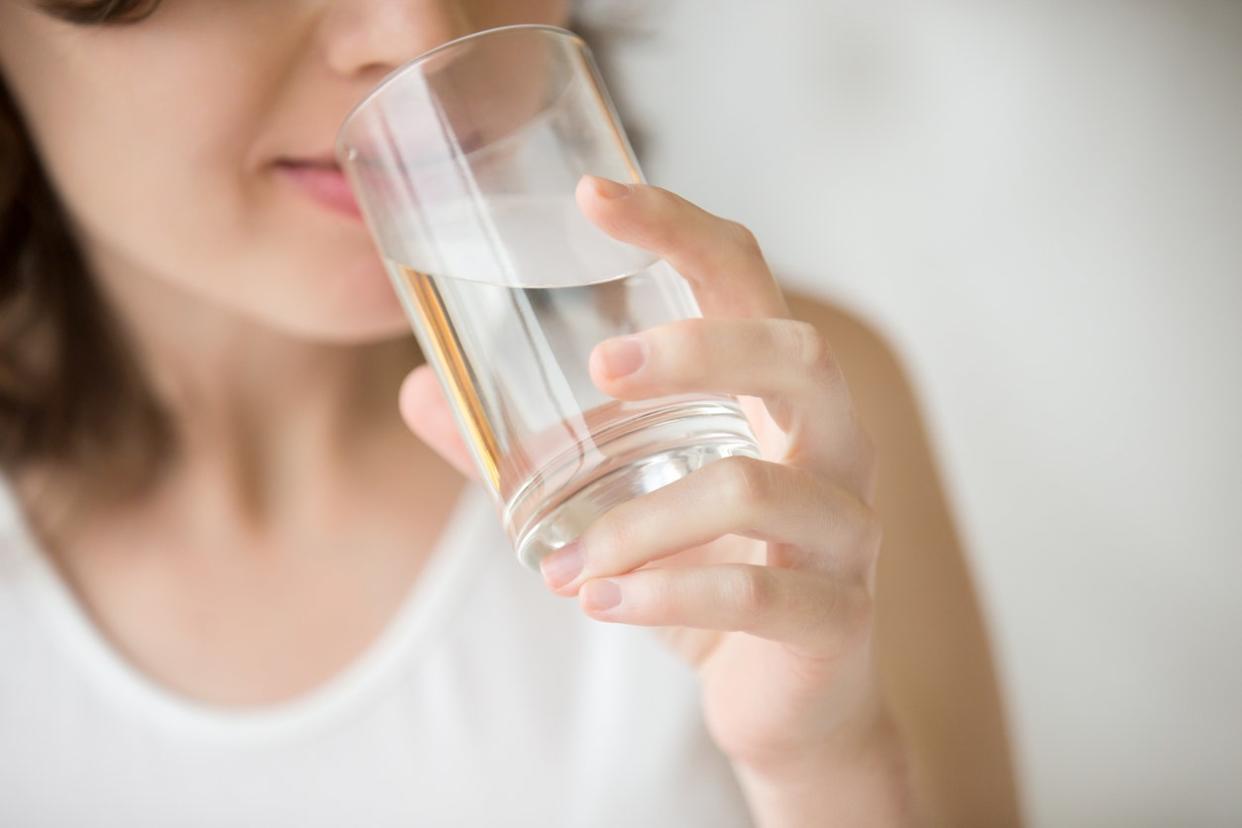 Happy beautiful young woman drinking water