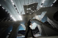 A woman walks by the diving platform at Tokyo Aquatics Center after its grand opening ceremony Saturday, Oct. 24, 2020, in Tokyo. The Tokyo 2020 organizing committee held the grand opening ceremony Saturday at the aquatics center, planned to host Olympic artistic swimming, diving and swimming and Paralympics swimming events in 2021. (AP Photo/Eugene Hoshiko)