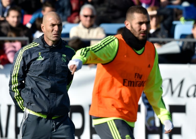 Real Madrid's Zinedine Zidane (L) watches forward Karim Benzema during his first training session as coach at the Alfredo di Stefano Stadium in Valdebebas, on the outskirts of Madrid, on January 5, 2016