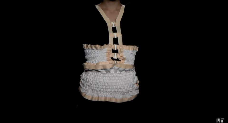 A woman wearing a truss consisting of "robotic fibers" that can monitor a wearer's breathing. An example of smart clothes.