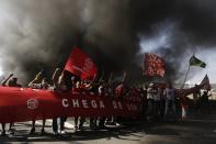 Members of Brazil's Homeless Workers' Movement (MTST), who are living at the "People's World Cup Camp" which houses some 2,800 families of the movement in the district of Itaquera near Sao Paulo's World Cup stadium, Arena de Sao Paulo, block a road during a protest against the World Cup in Sao Paulo, May 15, 2014. Brazilians opposed to the World Cup and the public funds spent on the construction of stadiums called for a day of protest around the country. REUTERS/Nacho Doce (BRAZIL - Tags: SPORT SOCCER WORLD CUP CIVIL UNREST)