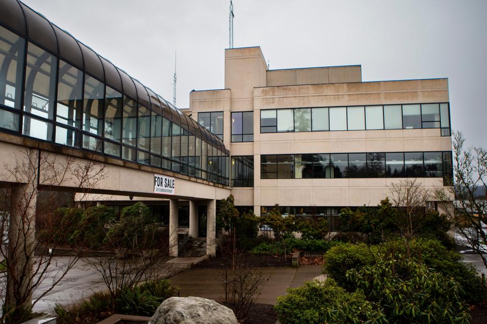 A for sale sign hangs from a bridge at the former Eugene Water and Electric Board headquarters along the riverfront in Eugene. 