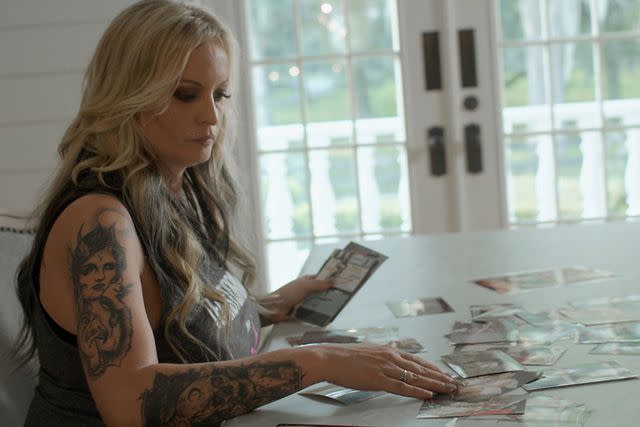 <p>Peacock</p> Stormy Daniels looks through family photos in "Stormy," now streaming on Peacock