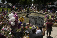 People visit a memorial set up in a town square to honor the victims killed in this week's elementary school shooting in Uvalde, Texas Saturday, May 28, 2022. (AP Photo/Jae C. Hong)