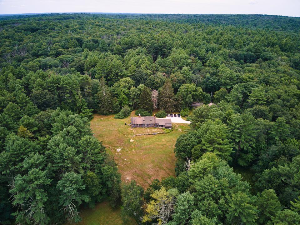 The remote farmhouse is surrounded by the woods.