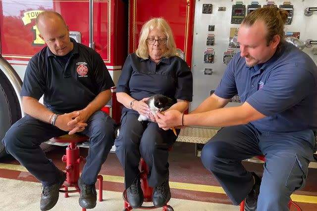 <p>Raynham Fire Department</p> Raynham Fire Department officers spend time with the kitten they helped rescue.