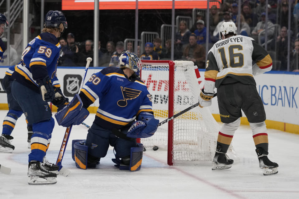 Vegas Golden Knights' Pavel Dorofeyev (16) scores past St. Louis Blues goaltender Jordan Binnington (50) and Nikita Alexandrov (59) during the third period of an NHL hockey game Sunday, March 12, 2023, in St. Louis. (AP Photo/Jeff Roberson)