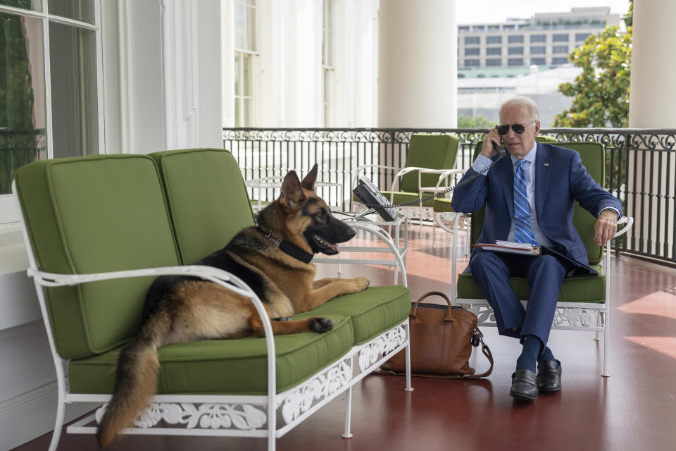 In this image provided by the White House, President Joe Biden speaks on the phone with White House chief of staff Ron Klain from the Truman Balcony, Monday, July 25, 2022, at the White House in Washington. (Adam Schultz/The White House via AP)