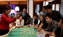 Trainee casino dealers practise on a roulette table inside Solaire Casino in Pasay city, Metro Manila, Philippines, March 27, 2015. The Philippines has emerged as one of Asia's hottest gambling hubs after it launched its 120-hectare (1.2 square km) gaming and leisure enclave called Entertainment City in the capital, modelled on the Las Vegas strip. When paying your final respects for a relative or friend, the last thing you might expect to see at the wake is people placing bets on a card game or bingo. Not in the Philippines. Filipinos, like many Asians, love their gambling. But making wagers on games such as "sakla", the local version of Spanish tarot cards, is particularly common at wakes because the family of the deceased gets a share of the winnings to help cover funeral expenses. Authorities have sought to regulate betting but illegal games persist, with men and women, rich and poor, betting on anything from cockfighting to the Basque hard-rubber ball game of jai-alai, basketball to spider races. Many told Reuters photographer Erik De Castro that gambling is only an entertaining diversion in a country where two-fifths of the population live on $2 a day. But he found that some gamble every day. Casino security personnel told of customers begging to be banned from the premises, while a financier who lends gamblers money at high interest described the dozens of vehicles and wads of land titles given as collateral by those hoping lady luck would bring them riches. REUTERS/Erik De Castro PICTURE 15 OF 29 FOR WIDER IMAGE STORY "HIGH STAKES IN MANILA". SEARCH "BINGO ERIK" FOR ALL IMAGES.