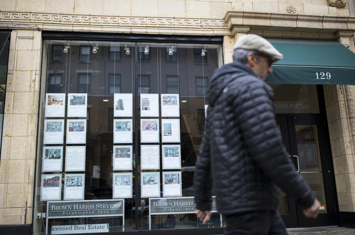 Pedestrians walk past the Brown Harris Stevens real estate office in Brooklyn Heights, New York. (Credit: Robert Nickelsberg/Getty Images)