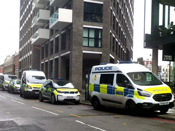 Police at the scene on Buckle Street, Whitechapel, east London, after a man died and another three were injured on 23 November (PA)