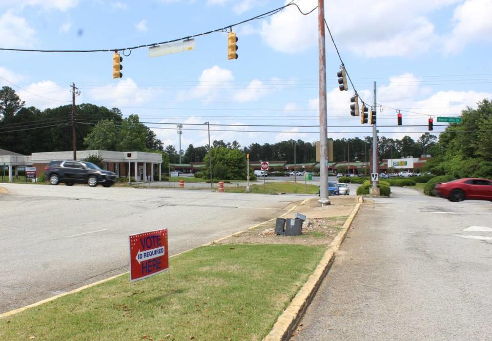 Small red signs that read “vote here” with an arrow point toward the Macon Mall entrance on Mercer University Drive.