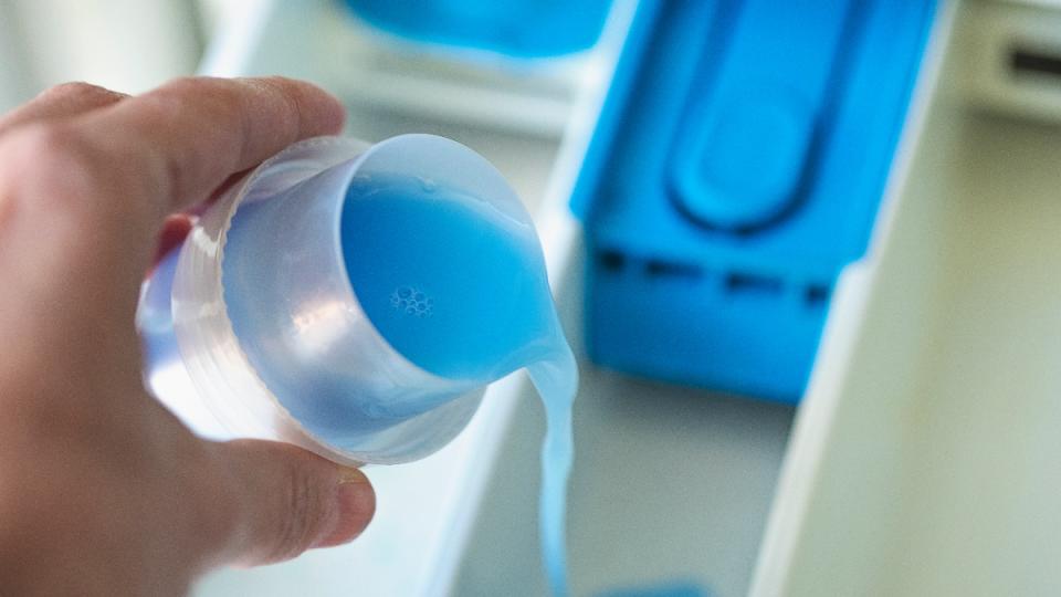 hand pouring detergent for how to make laundry smell good