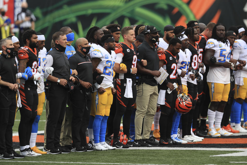 The Cincinnati Bengals and Los Angeles Chargers stand together arm in arm before for an NFL football game, Sunday, Sept. 13, 2020, in Cincinnati. (AP Photo/Aaron Doster)