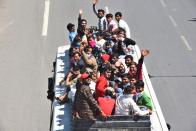 NEW DELHI, INDIA - MARCH 28: Migrant workers wave from on top of a bus bound to their native state, at Ghazipur, near the Delhi - UP border on Day 4 of the 21 day nationwide lockdown -- to check the spread of coronavirus, on March 28, 2020 in New Delhi, India. (Photo by Raj K Raj/Hindustan Times via Getty Images)