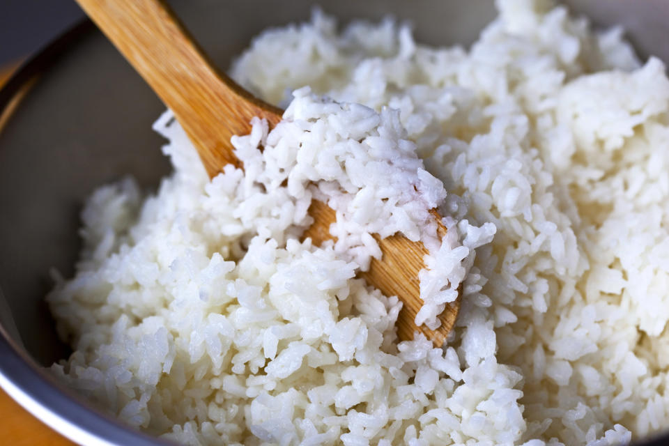 Rice in pot being stirred with wooden spoon