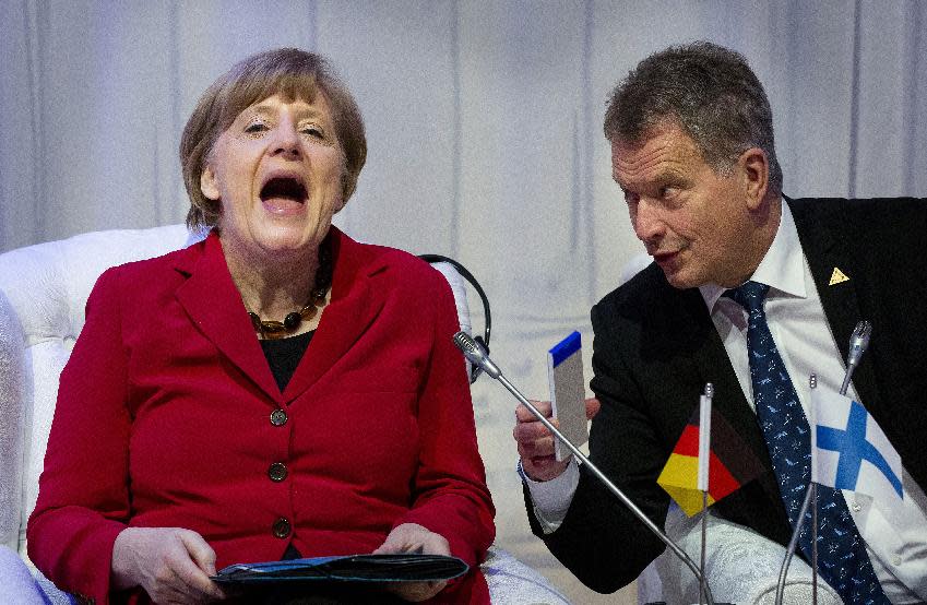 German Chancellor Angela Merkel, laughs talking to Finland's President Sauli Niinisto, right, as they attend an informal plenary session on the last day of the Nuclear Security Summit (NSS) in The Hague, Netherlands, Tuesday, March 25, 2014. (AP Photo/Bart Maat, POOL)